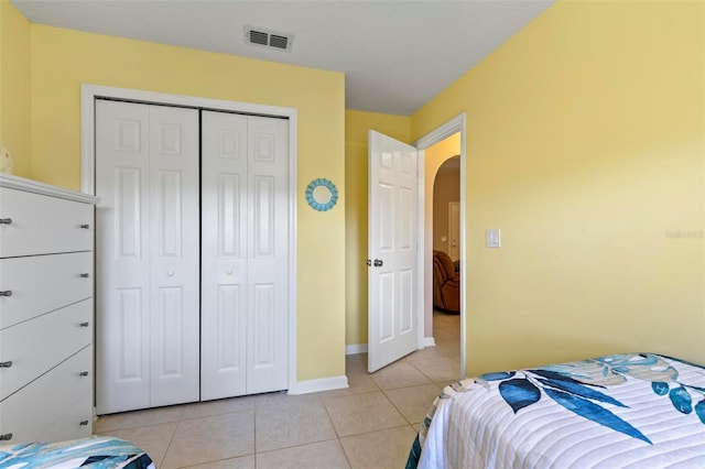 tiled bedroom with a closet