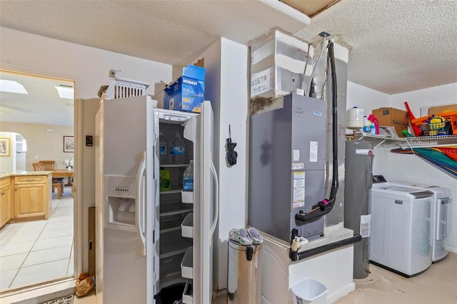 utility room with electric water heater and washing machine and dryer