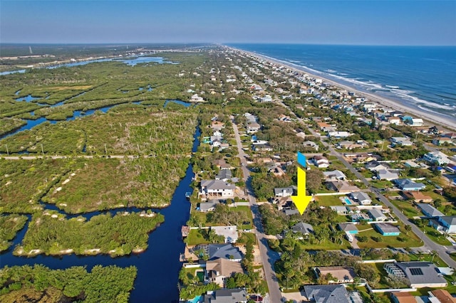 bird's eye view with a water view and a beach view