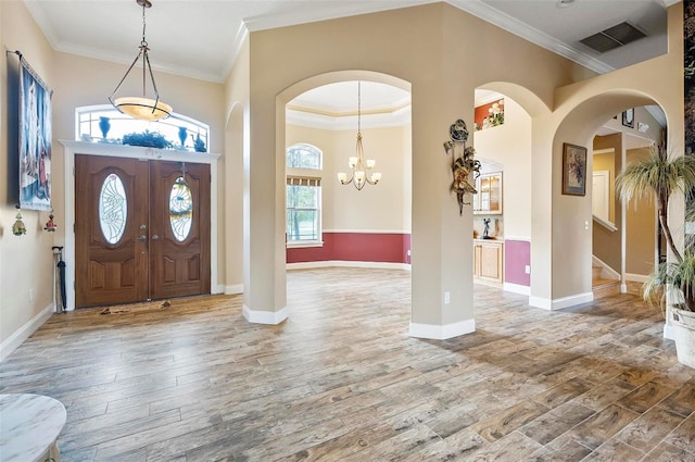 foyer entrance with crown molding, hardwood / wood-style floors, and plenty of natural light