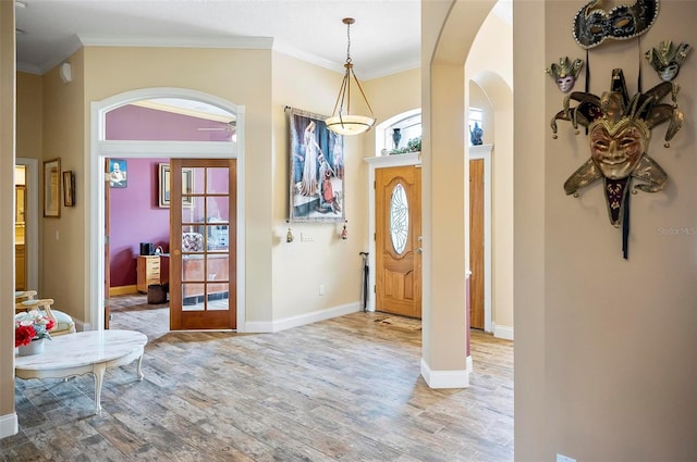 foyer featuring crown molding, lofted ceiling, light wood-type flooring, and ceiling fan