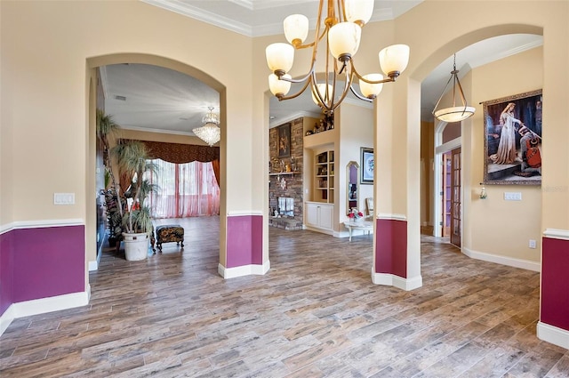 kitchen with hanging light fixtures, ornamental molding, a fireplace, and hardwood / wood-style floors