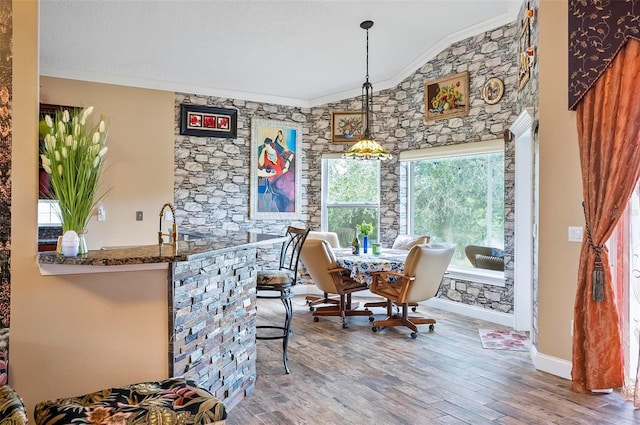 dining room featuring crown molding, lofted ceiling, and hardwood / wood-style floors