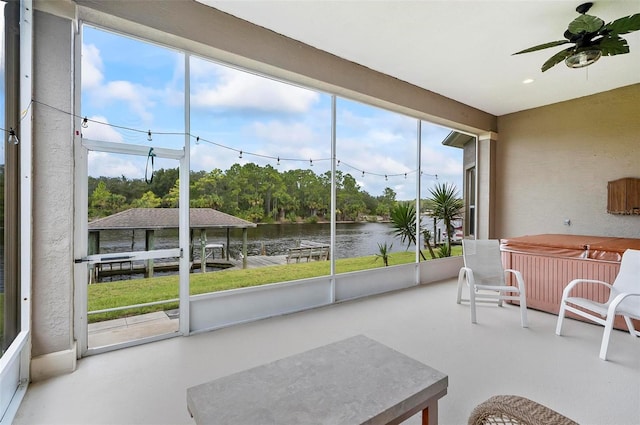 sunroom / solarium with a water view, ceiling fan, and a wealth of natural light