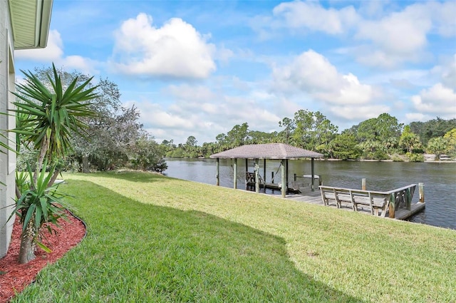 view of dock with a yard and a water view