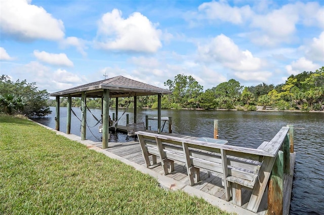 view of dock with a water view and a yard