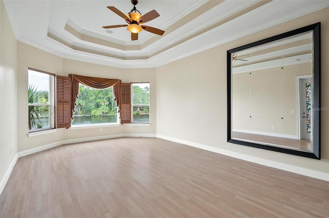 unfurnished room featuring crown molding, hardwood / wood-style flooring, a tray ceiling, and ceiling fan