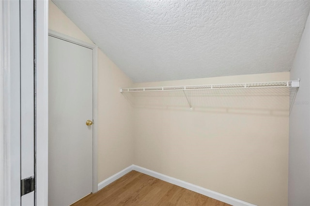 walk in closet featuring lofted ceiling and wood-type flooring