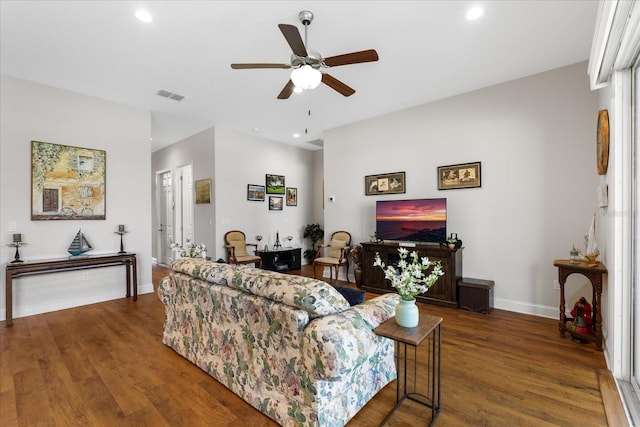 living room featuring dark wood-type flooring and ceiling fan