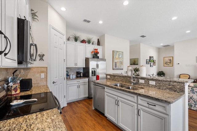 kitchen with sink, appliances with stainless steel finishes, dark wood-type flooring, and white cabinets