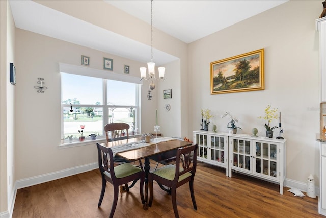 dining area with a notable chandelier and dark hardwood / wood-style flooring