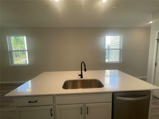 kitchen with sink, light stone counters, white cabinets, a center island with sink, and stainless steel dishwasher