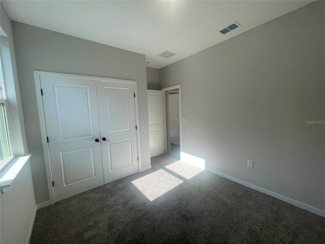 unfurnished bedroom with carpet flooring and a closet