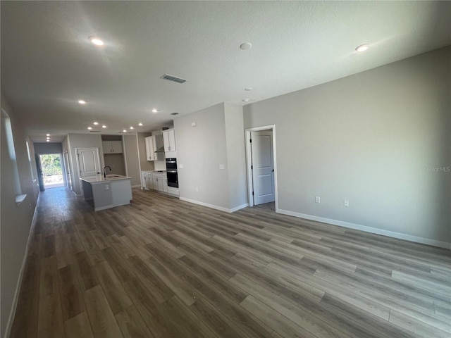 unfurnished living room with sink and dark hardwood / wood-style floors