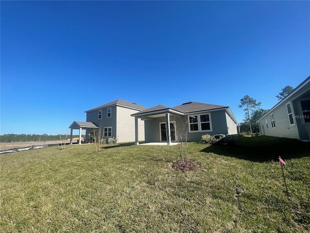 rear view of house featuring a yard and a patio