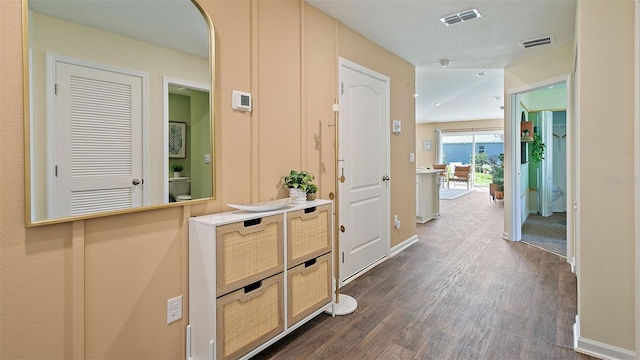 hallway featuring a textured ceiling and dark hardwood / wood-style floors