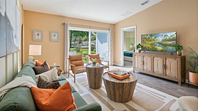 living room featuring light hardwood / wood-style floors and vaulted ceiling