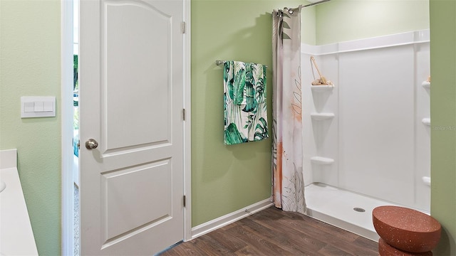 bathroom with curtained shower and hardwood / wood-style flooring