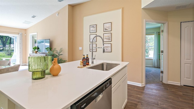 kitchen with white cabinets, an island with sink, dark hardwood / wood-style flooring, stainless steel dishwasher, and sink