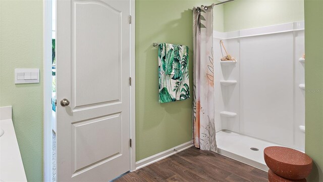 bathroom with a shower with curtain and wood-type flooring