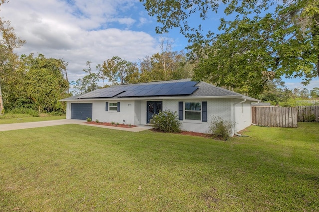 ranch-style home featuring solar panels, a front lawn, and a garage