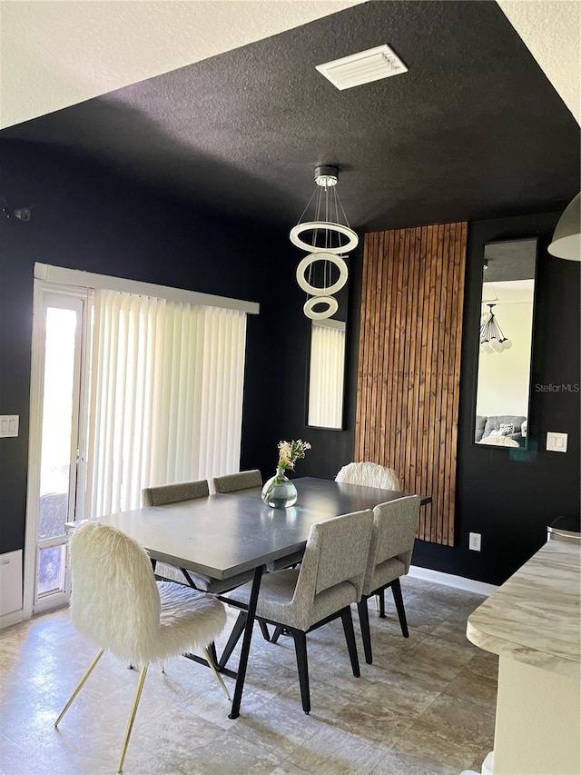 dining space featuring a chandelier and a textured ceiling