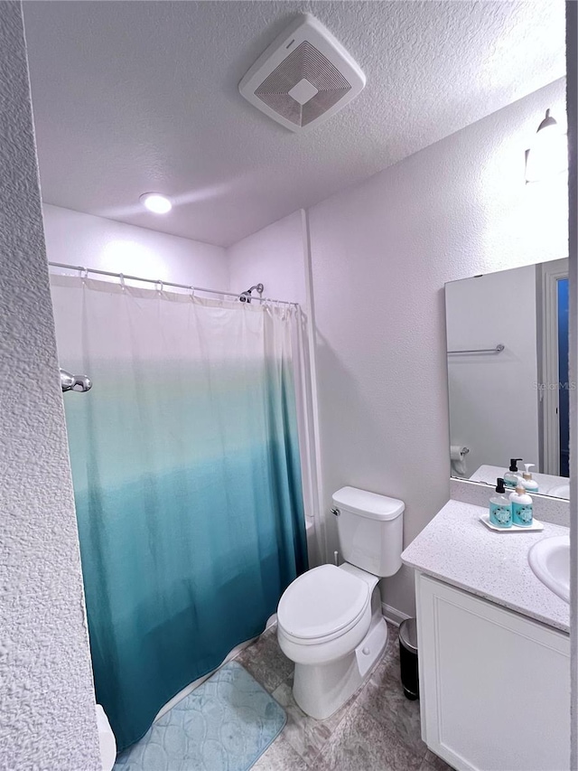 bathroom featuring toilet, a textured ceiling, curtained shower, and vanity