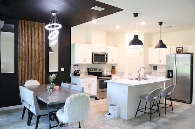 kitchen featuring a kitchen island with sink, sink, white cabinets, and stainless steel appliances