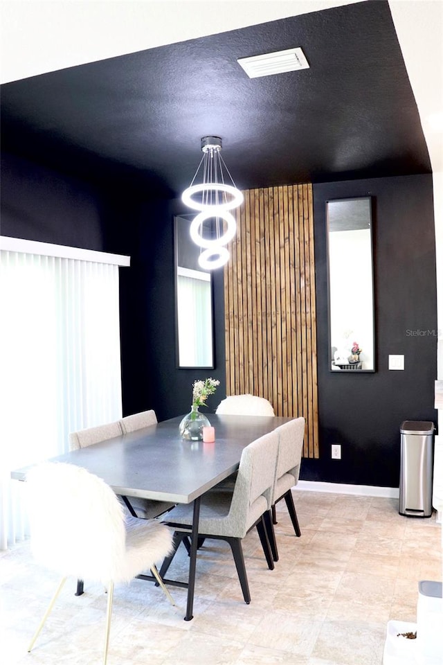 dining space with a textured ceiling, a chandelier, and a wealth of natural light