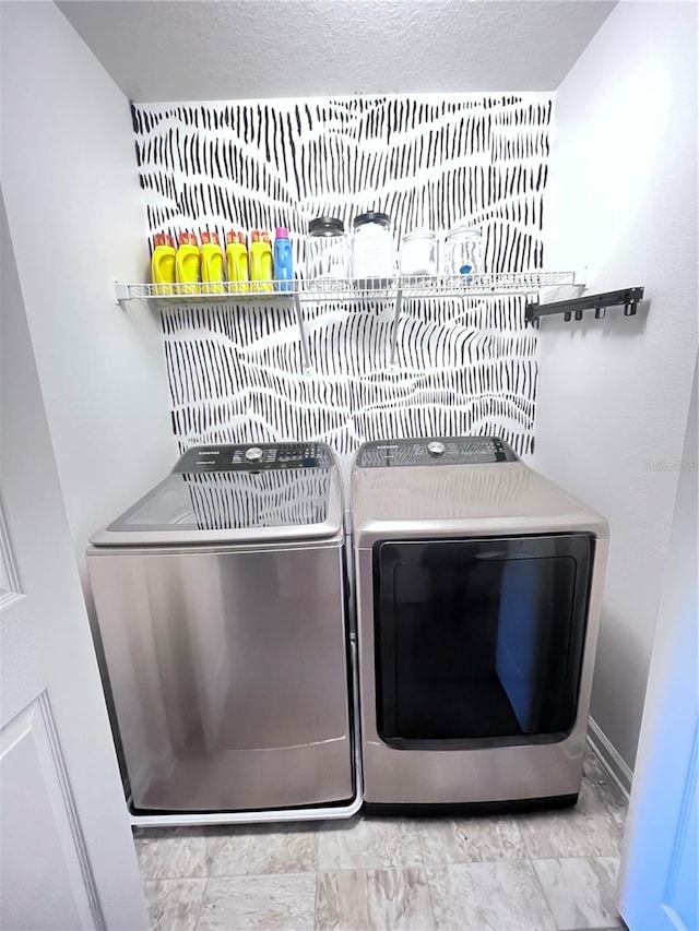 laundry room with washer and dryer and a textured ceiling