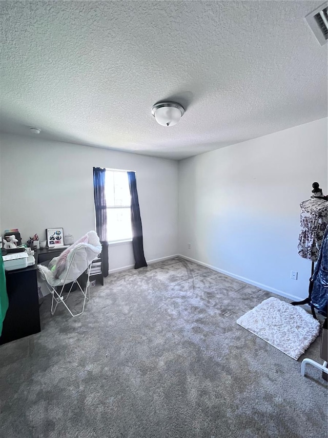 interior space featuring dark colored carpet and a textured ceiling