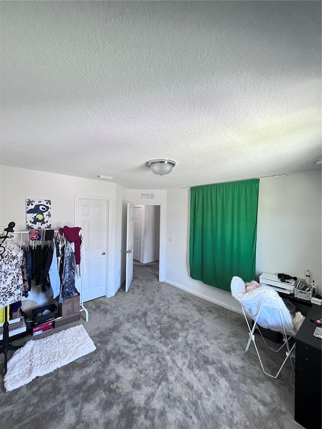 carpeted office featuring a textured ceiling