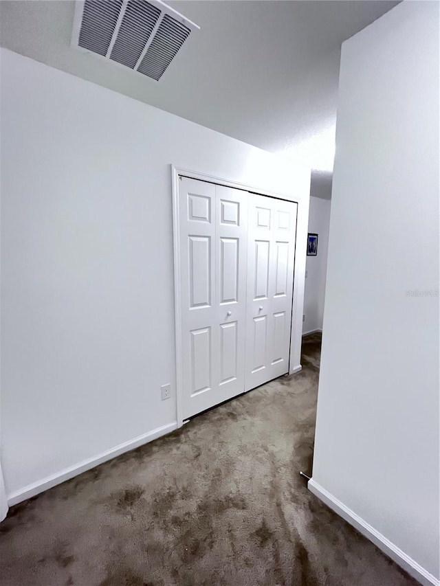 unfurnished bedroom with carpet flooring and a closet