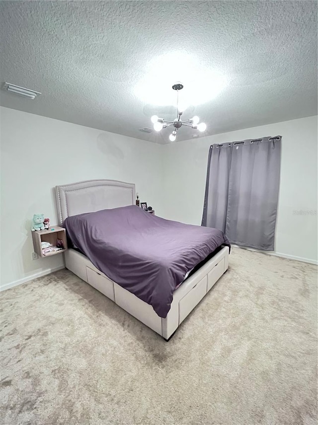 bedroom featuring a textured ceiling, a chandelier, and light colored carpet