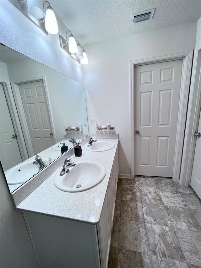 bathroom with vanity and a textured ceiling