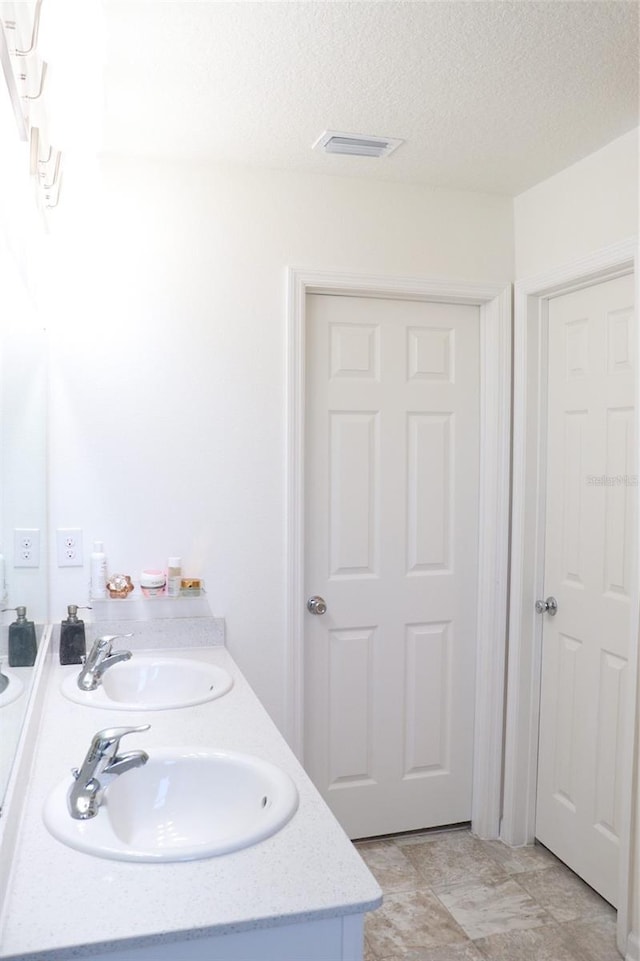 bathroom featuring vanity and a textured ceiling