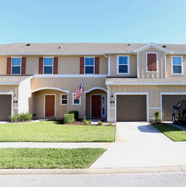 view of property with a front lawn and a garage