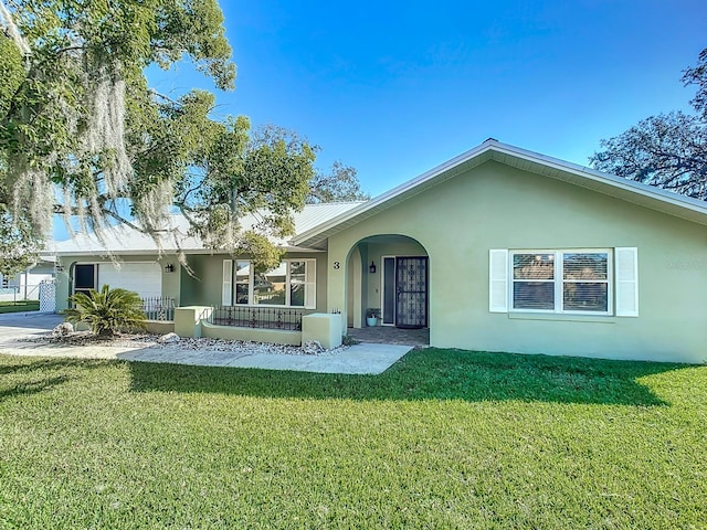 view of front facade with a porch, a front lawn, and a garage