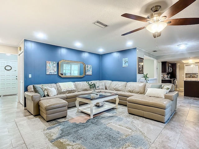 living room with a textured ceiling and ceiling fan