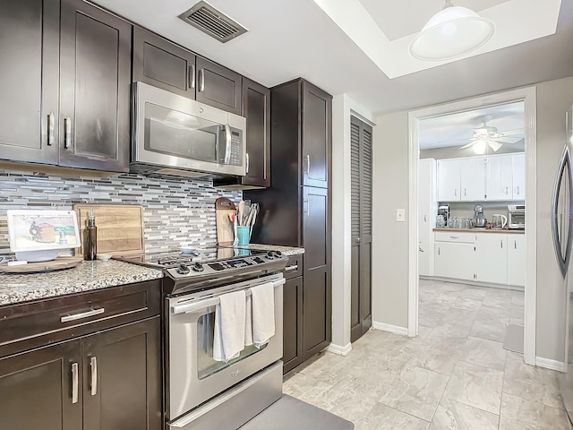 kitchen featuring dark brown cabinets, ceiling fan, stainless steel appliances, and tasteful backsplash