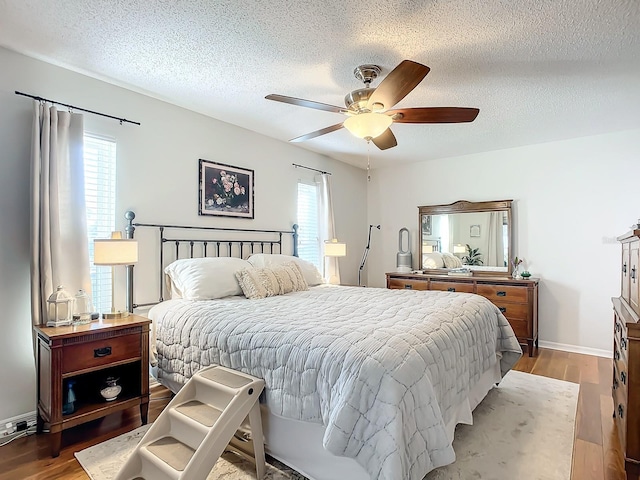 bedroom featuring a textured ceiling, light wood-type flooring, and ceiling fan