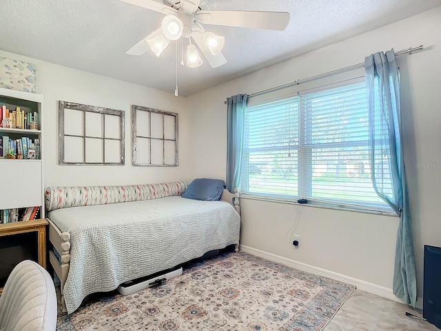 bedroom with ceiling fan and a textured ceiling