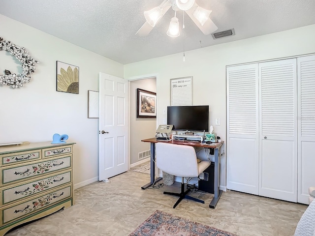 office area with baseboards, visible vents, a ceiling fan, and a textured ceiling