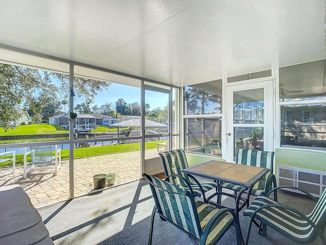 sunroom / solarium with a water view