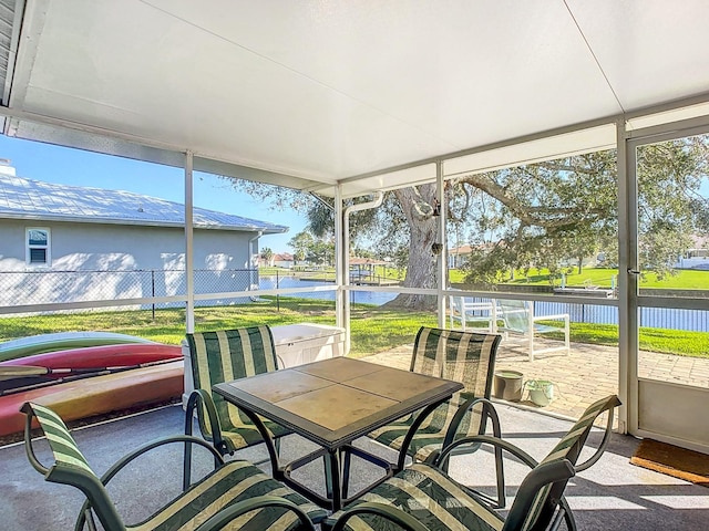 sunroom featuring a water view