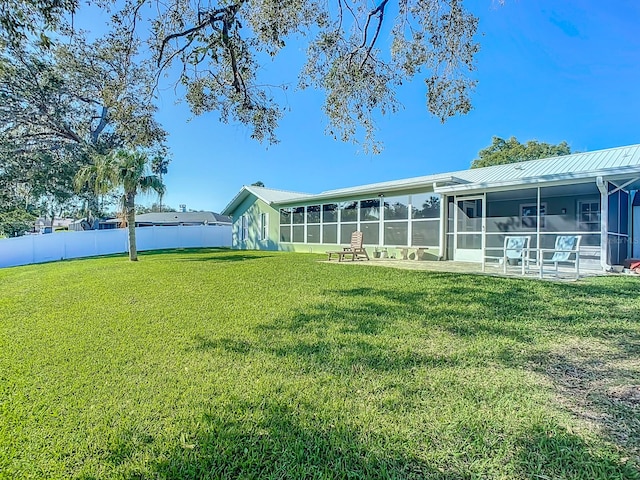 rear view of house featuring a yard and a sunroom