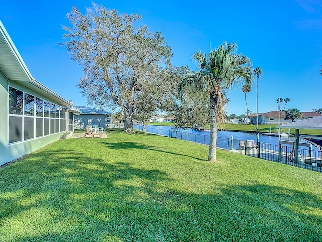 view of yard featuring a water view and a sunroom