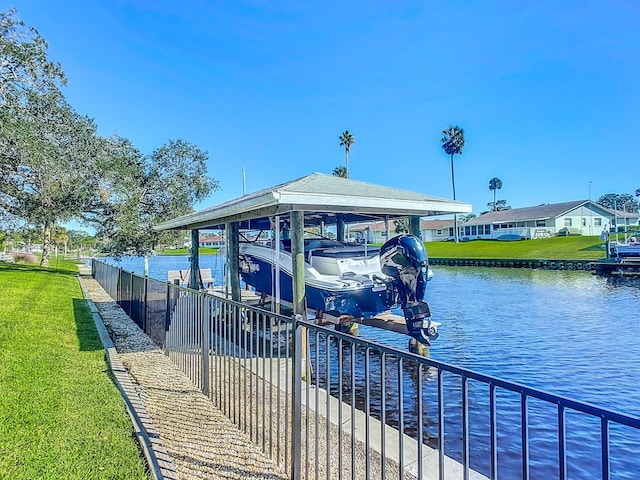 view of dock with a yard and a water view