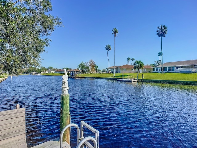 view of dock featuring a water view and a lawn