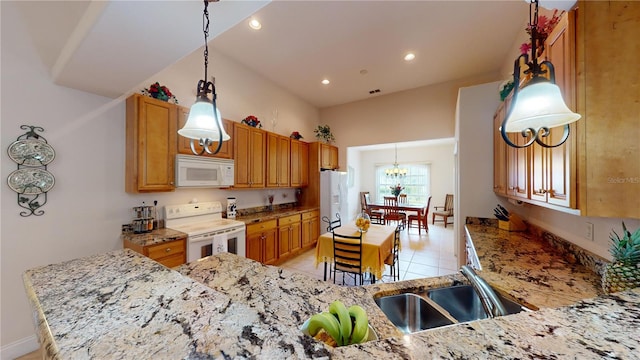 kitchen with hanging light fixtures, light stone counters, light tile patterned flooring, sink, and white appliances